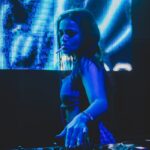 a woman that is standing in front of a dj mixer