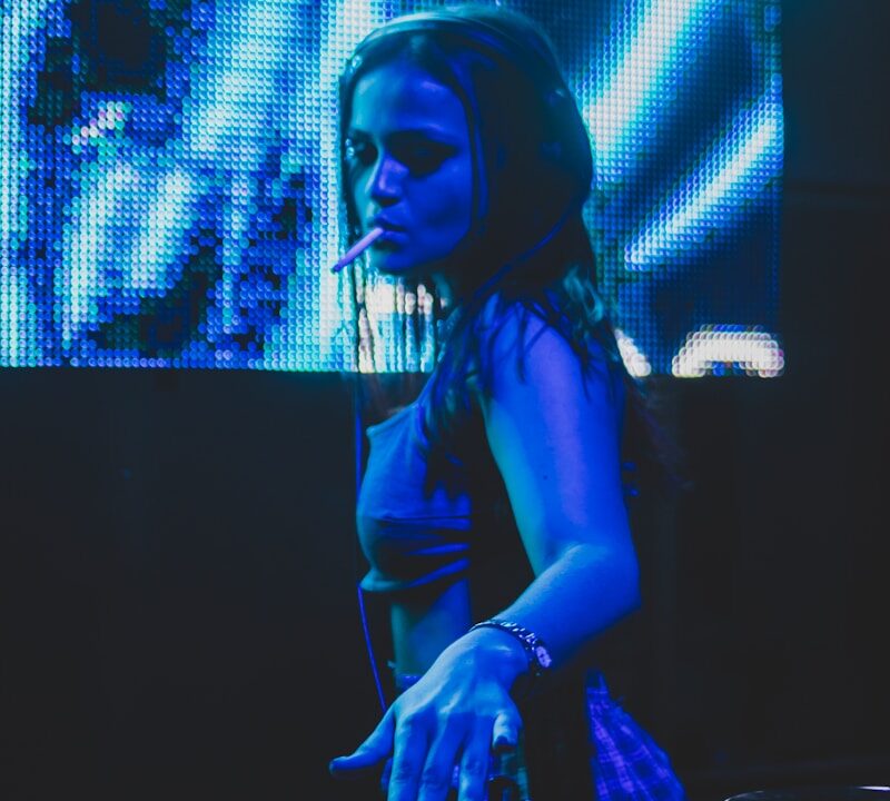 a woman that is standing in front of a dj mixer